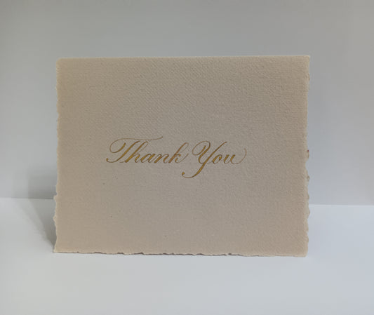 Beige card with 'Thank You' in gold on a white background